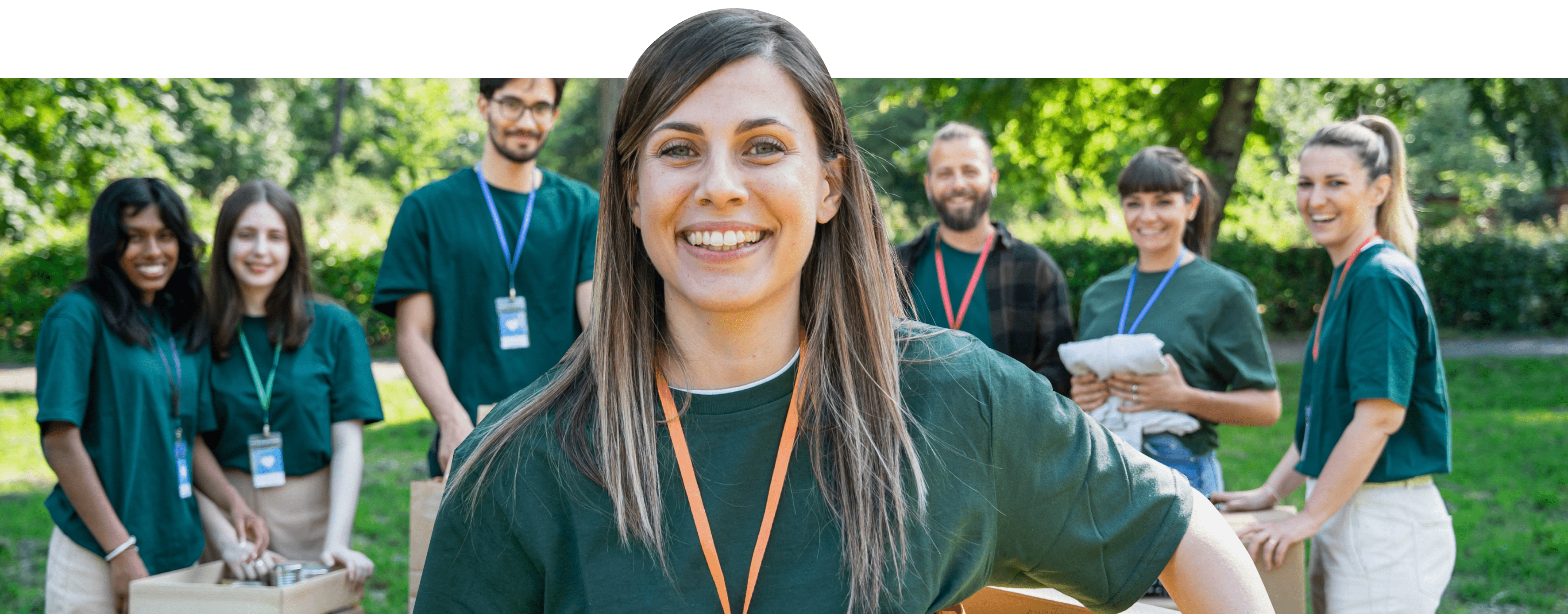 A volunteer smiling with their team behind them